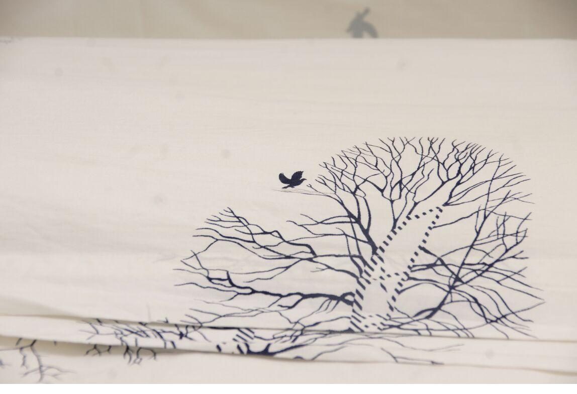 Motif brodé arbre et oiseau sur le linge de lit